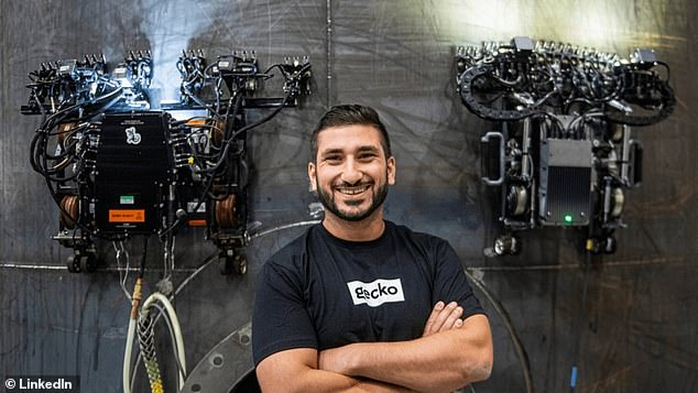 Jake Loosararian poses in front of his company's robotic wall crawlers