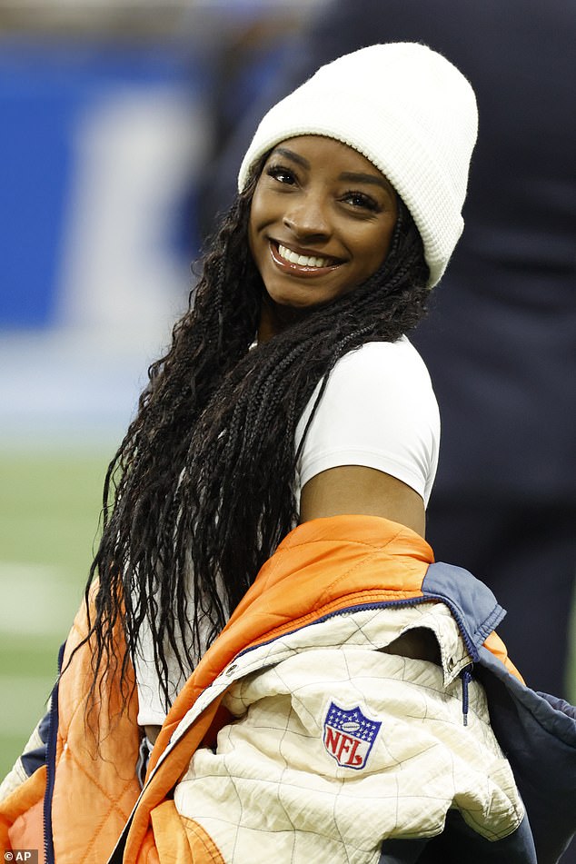 Simone Biles poses on the sidelines before the game after flying to Detroit for the big game