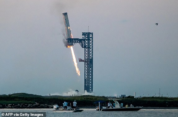 TOPSHOT - Starship's Super Heavy Booster engages on the launch pad at Starbase near Boca Chica, Texas, on October 13, 2024, during the Starship Flight 5 test. SpaceX successful "captured" the first stage booster of its Starship megarocket Sunday as it returned to the launch pad after a test flight, a world first in the company's quest for rapid reusability. (Photo by SERGIO FLORES/AFP) (Photo by SERGIO FLORES/AFP via Getty Images) *** BESTPIX ***