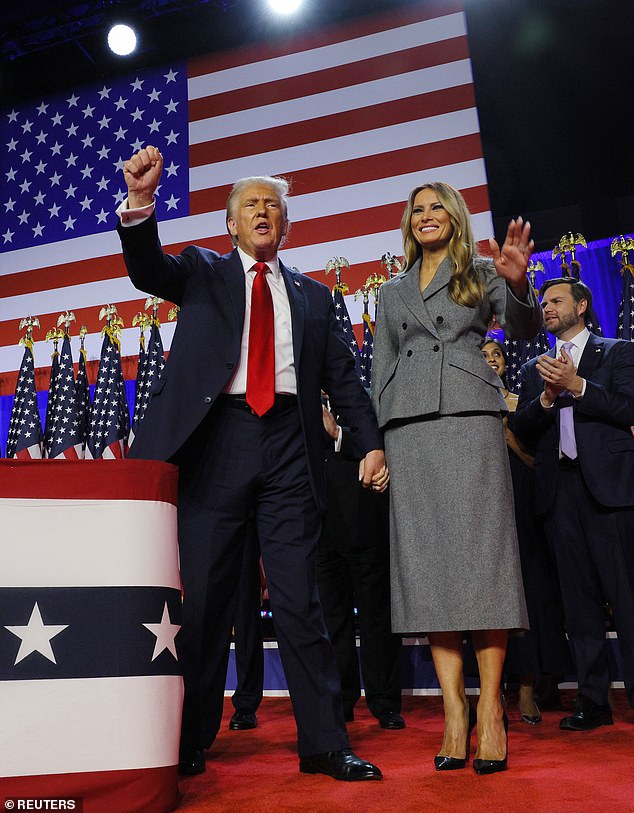 Donald Trump pumps the crowd at the Palm Beach County Convention Center with his fists as he holds the hand of his wife Melania