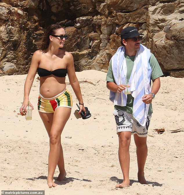 The fitness influence looked sensational as she showed off her growing baby bump with husband Josh Miller. Steph, 30, made sure all eyes were on her as she strolled along the beach in a bandeau bikini top paired with colorful striped shorts