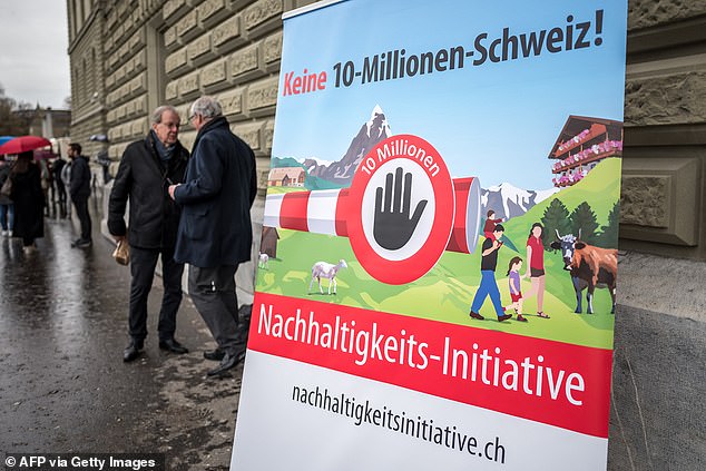 Representatives of the Swiss People's Party (SVP UDC) stand next to a banner that reads in German: 'No 10 million Switzerland! sustainability initiative' after handing over signatures needed for a Swiss popular initiative to vote to limit population growth in Switzerland, in Bern on April 3, 2024