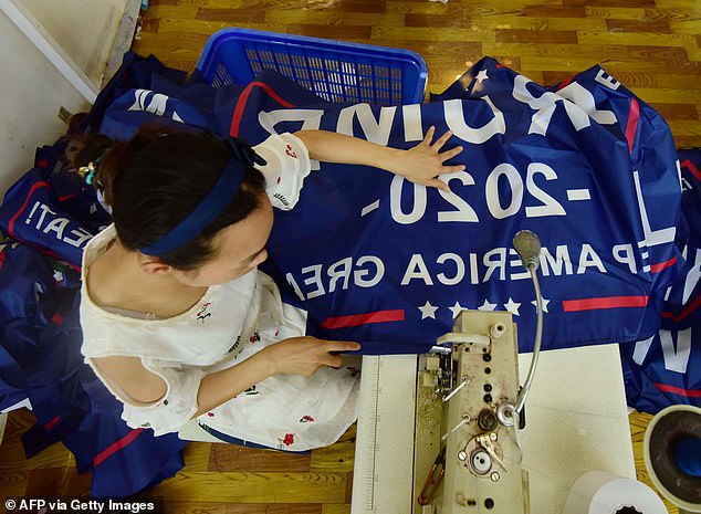 Yiwu, China is home to one of the world's largest wholesale markets in the world. Pictured: A Chinese worker sews a Trump 2020 Keep America Great flag