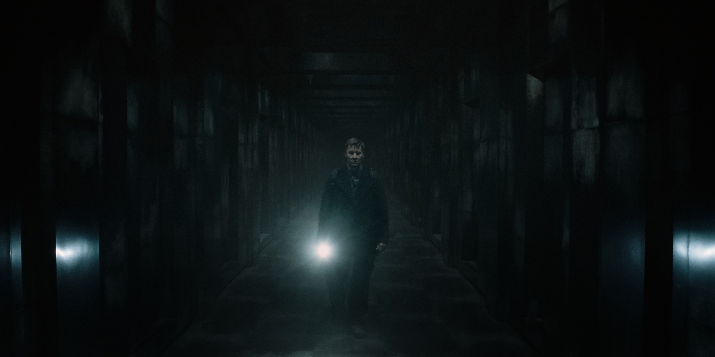 Jason (Joel Edgerton) walks with a flashlight in the liminal space between universes in a still from Dark Matter