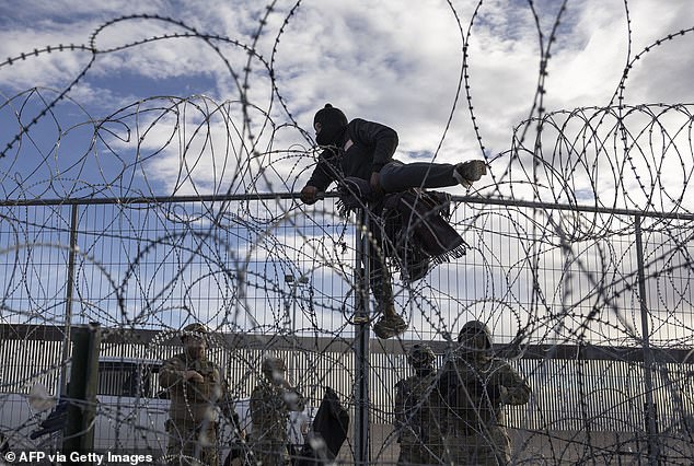 A migrant from Venezuela climbs a border fence in an attempt to enter El Paso, Texas, and seek asylum from Ciudad Juarez, Chihuahua, Mexico, on April 2, 2024