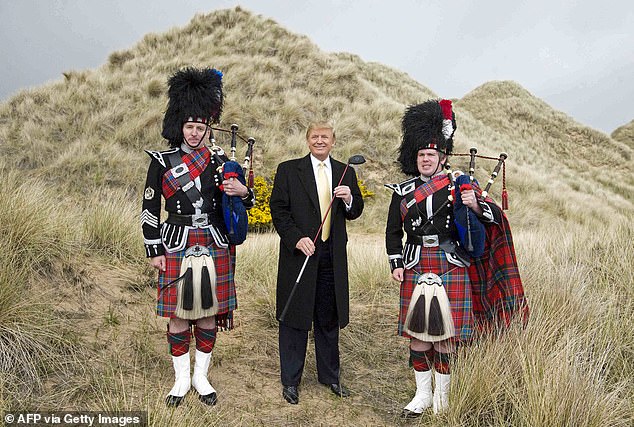 US President-elect Donald Trump (C) poses with Scottish pipers during a visit to the construction site of his golf course on the Menie Estate near Aberdeen