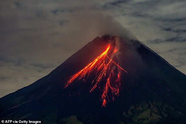 The volcano spews lava on its slopes during an eruption, seen from Srumbung village in Magelang, Central Java, on November 4, 2024