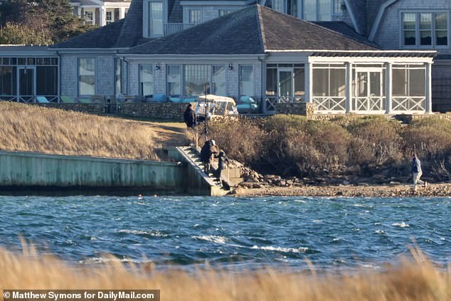 A Secret Service agent helps Jill Biden up the stairs from the beach