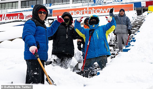 Hardcore members of the Bills mafia help clear snow from the stands before the game starts