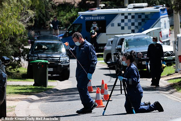 A forensics officer was seen video recording while a colleague marked the scene