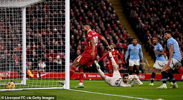 Salah set up Cody Gakpo (left) for Liverpool's first goal against Manchester City on Sunday