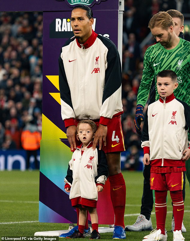 Dutchman Van Dijk pictured with a Liverpool mascot shortly before kick-off in Sunday's game