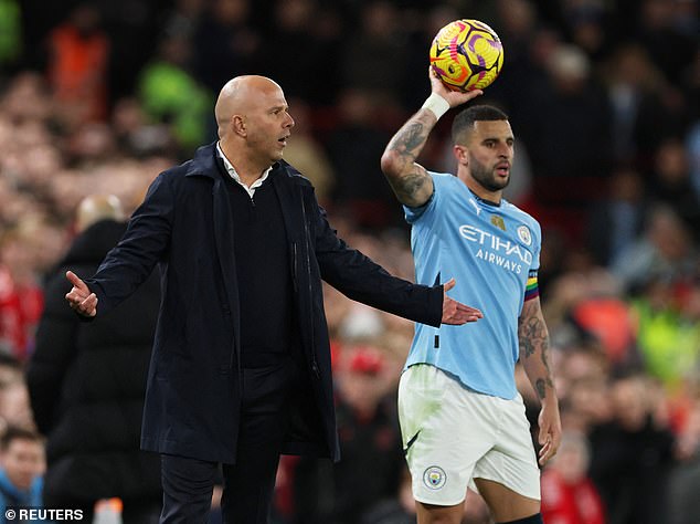 Walker pictured preparing to take a throw-in while standing near Reds manager Arne Slot (left)