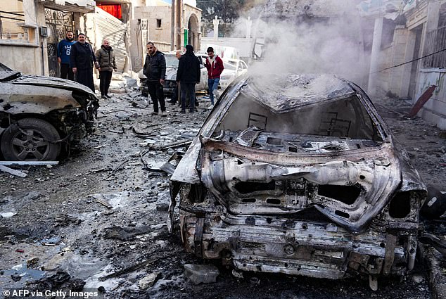 People view damage at the site of a Syrian regime air force strike that targeted a neighborhood in Syria's rebel-held northern city of Idlib on December 1, 2024.