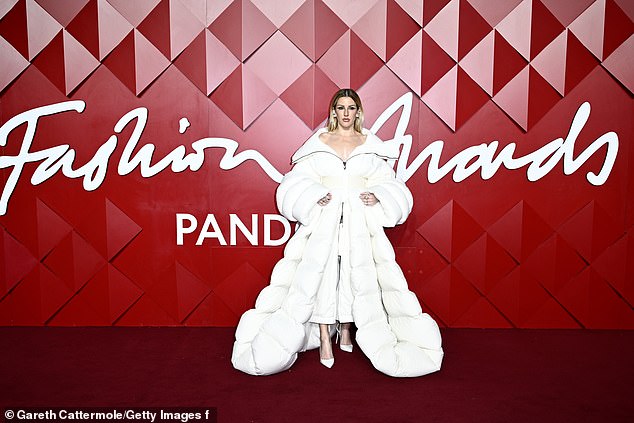 Ellie's impressive outerwear was worn over a white dress and teamed with a pair of classic white pumps and accessorized with large hoop earrings