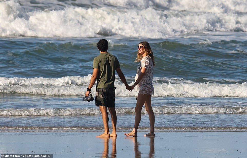 The couple held hands as they watched the waves crash in front of them