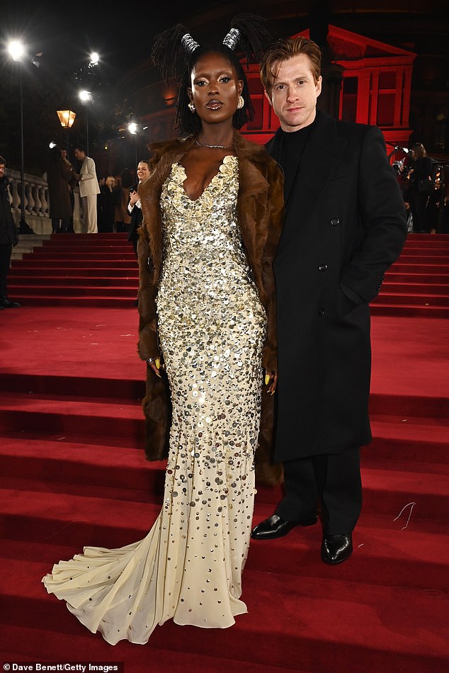 The mother-of-one also added a delicate silver chain and matching handbag for even more sparkle (pictured with Burberry Chief Creative Officer Daniel Lee)