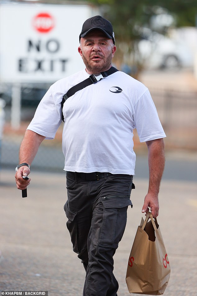 Clutching his car keys, the TV presenter wore a pair of chunky black sneakers while balancing a matching cap on his head.