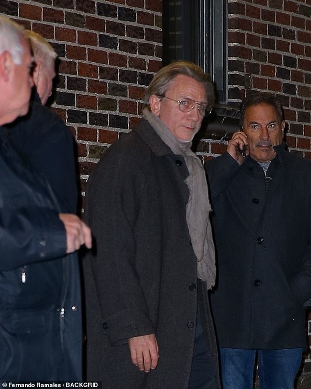 The actor, 56, wore a knee-length gray coat which he paired with a light gray scarf and jeans