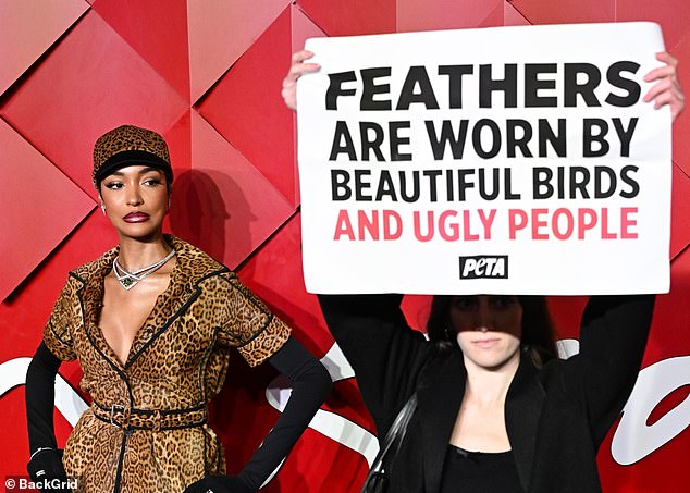 The activist held up a large sign condemning the use of fur, reading: 'Feathers are worn by beautiful birds and ugly people'