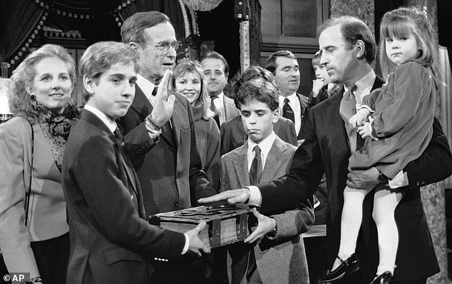 Ashley Biden in her father's arms (right) as he was sworn into Congress in 1985. Her brother Beau (left) holds up the Bible with his brother Hunter (center) as Ashley's mother Jill (far left) looks on