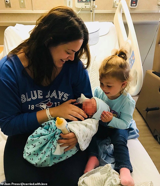 Mrs Taylor is pictured with her daughter Scarlet (right) and a baby she was carrying