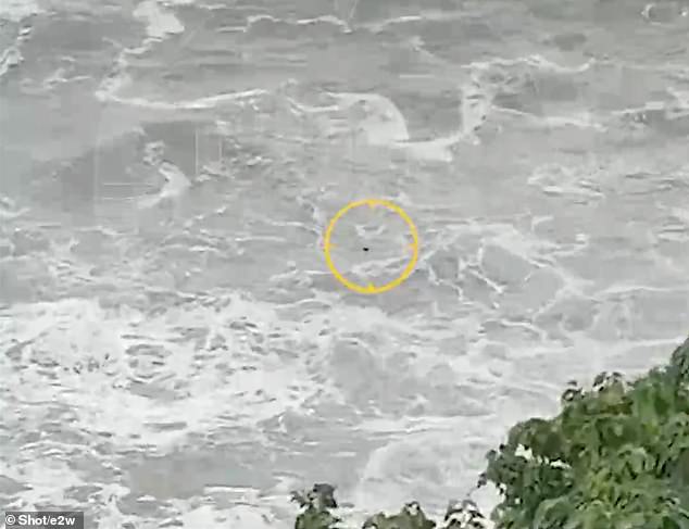 Footage showed a figure in the water as loud waves crashed overhead