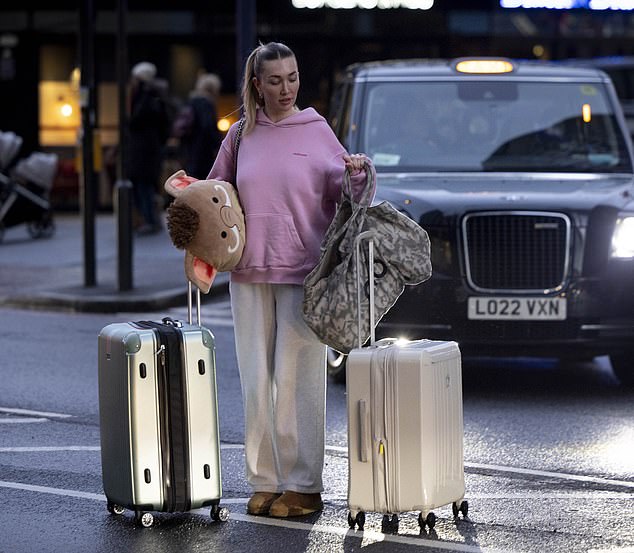 Kate wheeled two large suitcases to a waiting car while she and a friend retrieved items from the flat