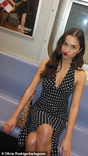 Olivia completed the look with bold red lipstick – to match her short, glossy manicure – and a leopard print handbag