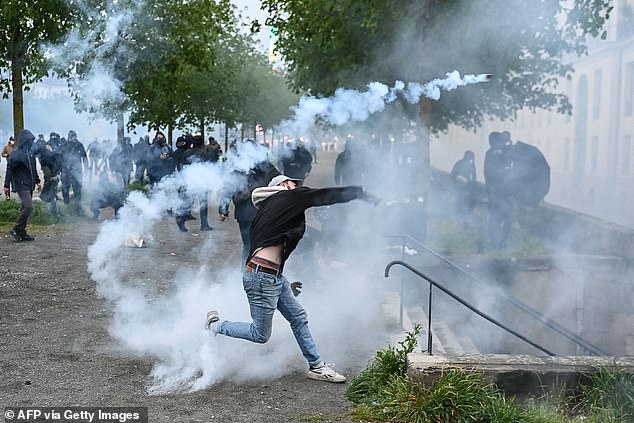 A protester throws a tear gas canister during clashes with police during a demonstration in Nantes last year