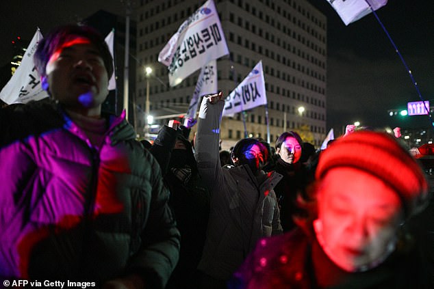 People gesture as they gather outside the National Assembly in Seoul on December 4, 2024, after South Korean President Yoon Suk Yeol declares martial law