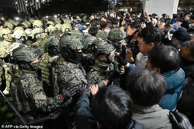 Soldiers attempt to enter the National Assembly building in Seoul on December 4, 2024, after South Korean President Yoon Suk Yeol declared martial law