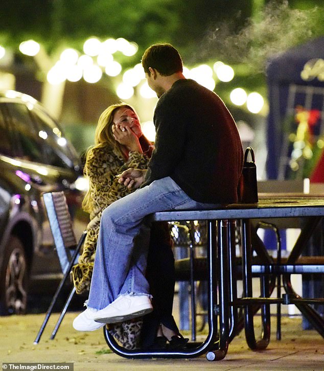 While they were deep in conversation, the model, 27, could be seen caressing her husband's arm as she hung on to his every word