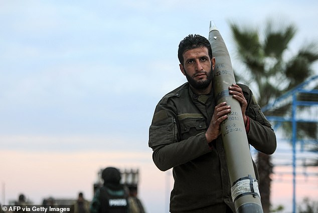 An anti-government fighter carries a missile to be used against regime forces, in the northern outskirts of Syria's west-central city of Hama on December 4, 2024