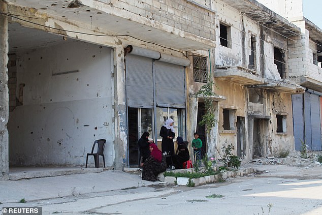 A family is seen in Homs. It is the third largest city in Syria and is located just 40 kilometers south of Hama