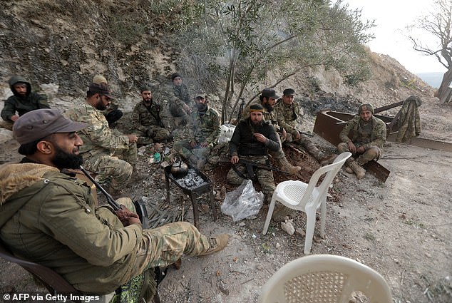 Anti-government fighters rest in a position in the northern outskirts of the west-central city of Hama in Syria on December 4, 2024