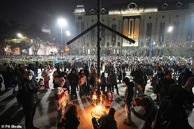 Protesters light candles during a rally (Pavel Bednyakov/AP)