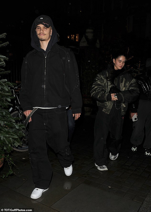 Kim beamed as she stepped out in a satin green bomber jacket atop a black and red Umbro tracksuit