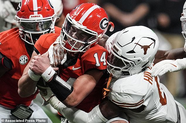 Texas linebacker Anthony Hill Jr. (0) hits Georgia quarterback Gunner Stockton (14)