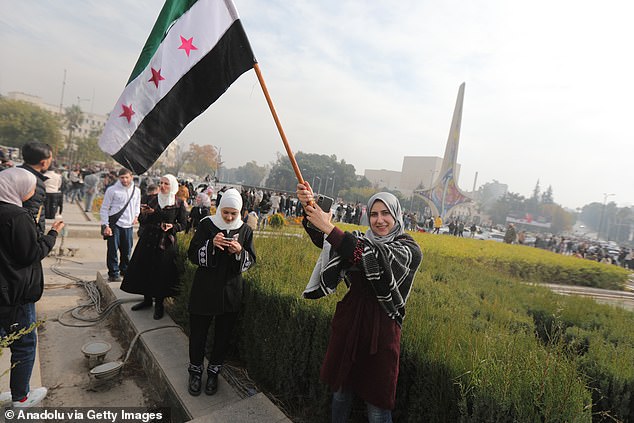 Syrians celebrate the collapse of 61 years of Baath Party rule in Damascus, waving rebel flags