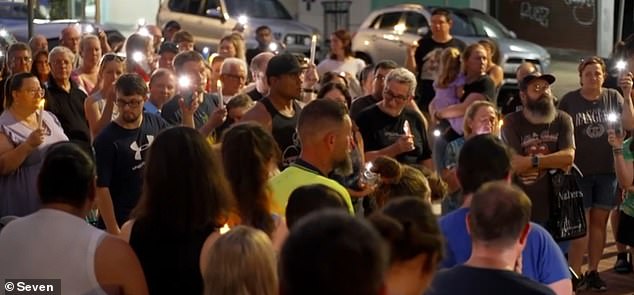 Hundreds of locals left flowers at the couple's burger shop at a candlelight vigil (pictured) this weekend and remembered giving free food to poverty-stricken customers