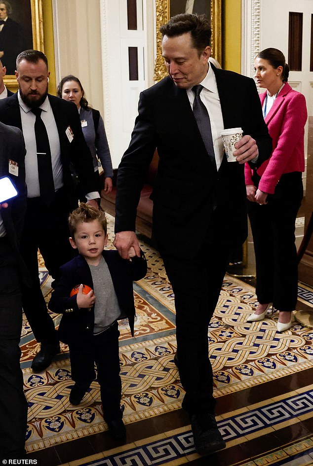 X was then seen holding tightly to his father's hand as he pushed his way through a crowd of reporters and photographers