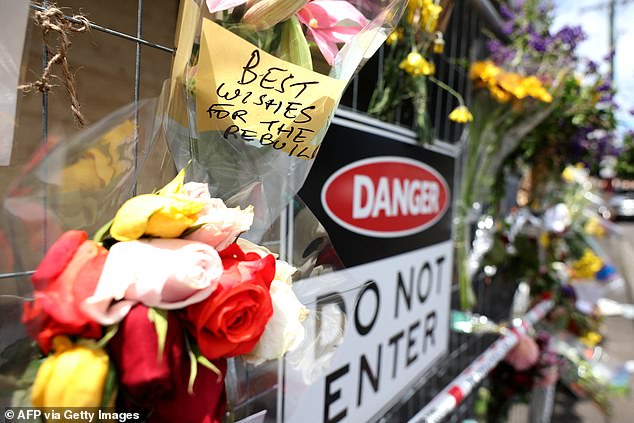 Messages and flowers are attached to the fence of the gutted Adass Israel Synagogue in Ripponlea in Melbourne's east