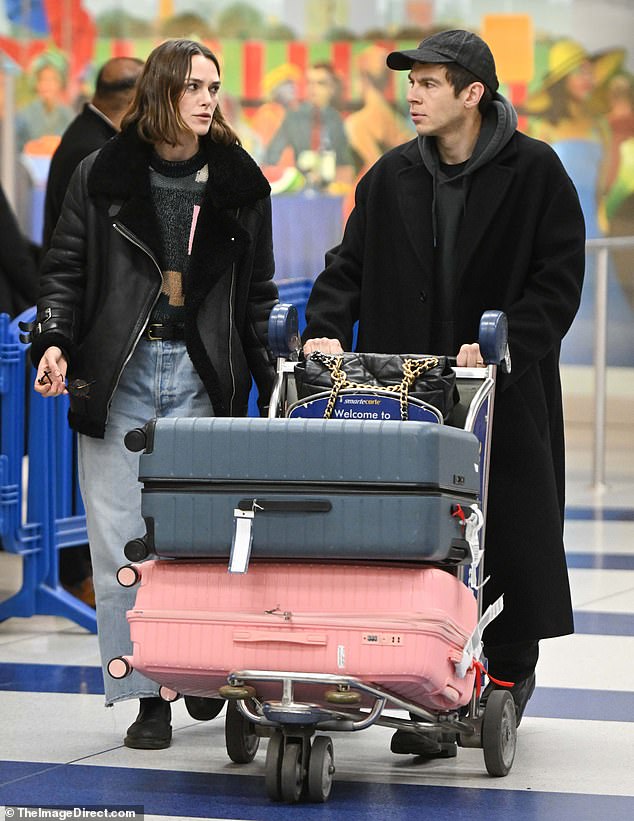 James looked stylish as he wore a black hoodie under a long coat, as well as a cap, as he pushed the trolley carrying their luggage