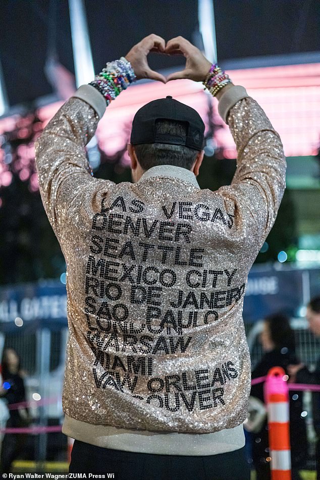 A fan wearing a jacket with all the Taylor Swift concerts they attended on the Eras Tour at the final show