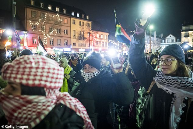 People attending the event in Germany turned on the lights on their phones to show solidarity