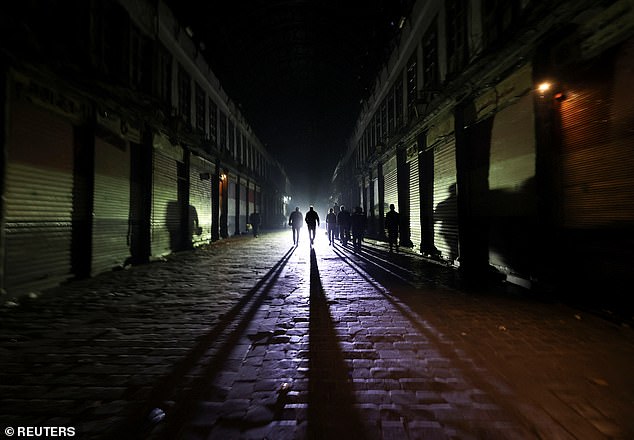 People walk next to closed shops during curfew after Syrian rebels announced they have ousted Syria's Bashar al-Assad in Damascus