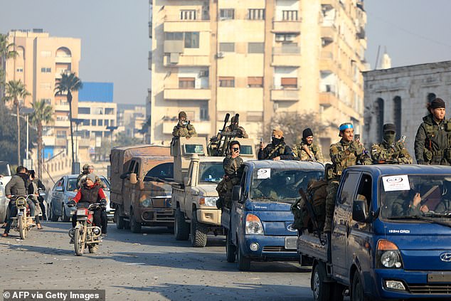 Rebels parade in the streets of Hama after troops captured the central city on December 6