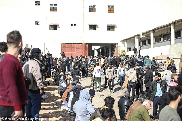 People wait today as teams investigate secret compartments of Sednaya Prison after the fall of the Assad regime in Damascus