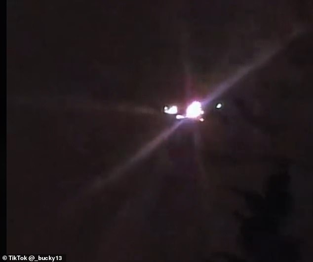 One UFO or drone in a recent Tik Tok video looks as if it has been floating silently beyond the tree line, illuminated by multiple lights that pulsed brightly enough to produce a lens flare effect